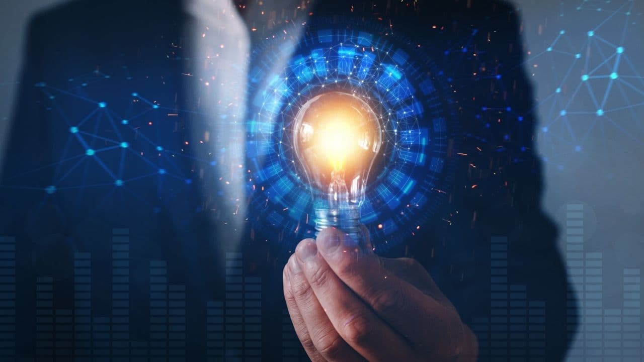 Businessman holding a light bulb as a symbol of decision-making in alignment with his energy