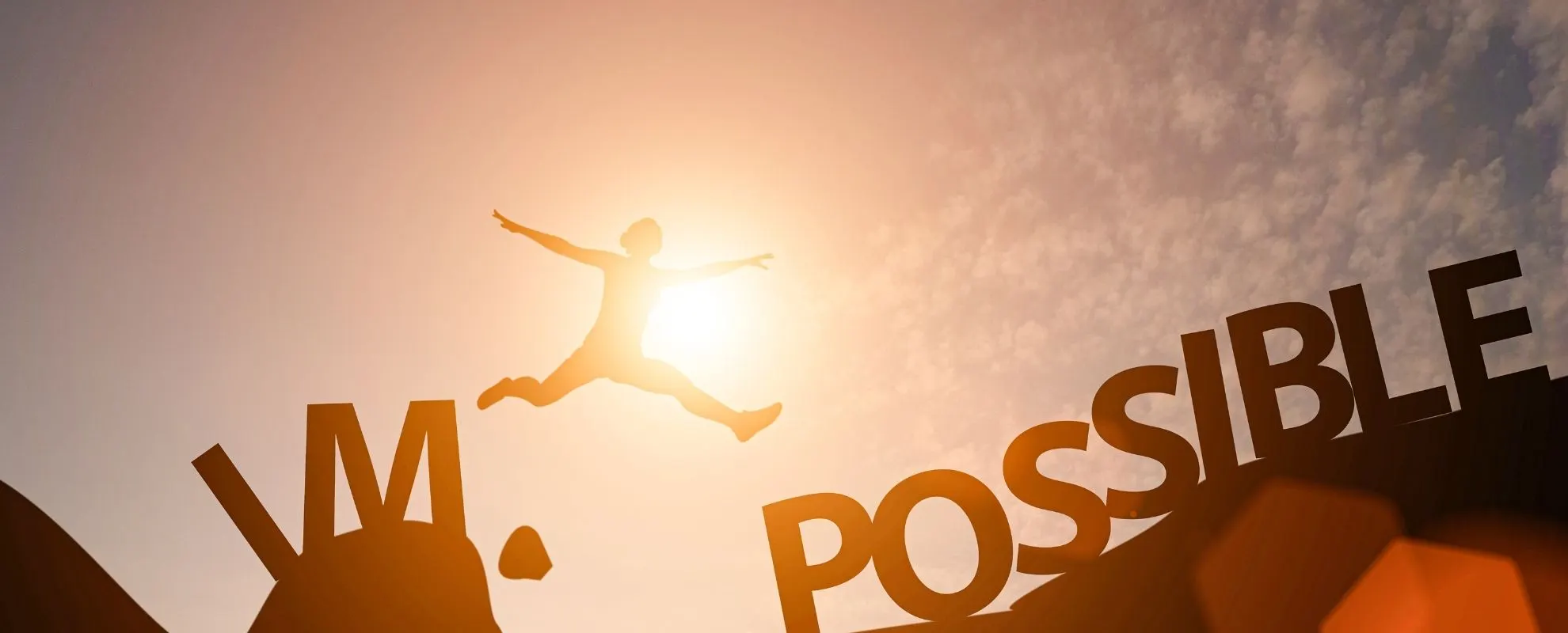 Silhouette leaping across the gap between the words “IM” and “POSSIBLE”