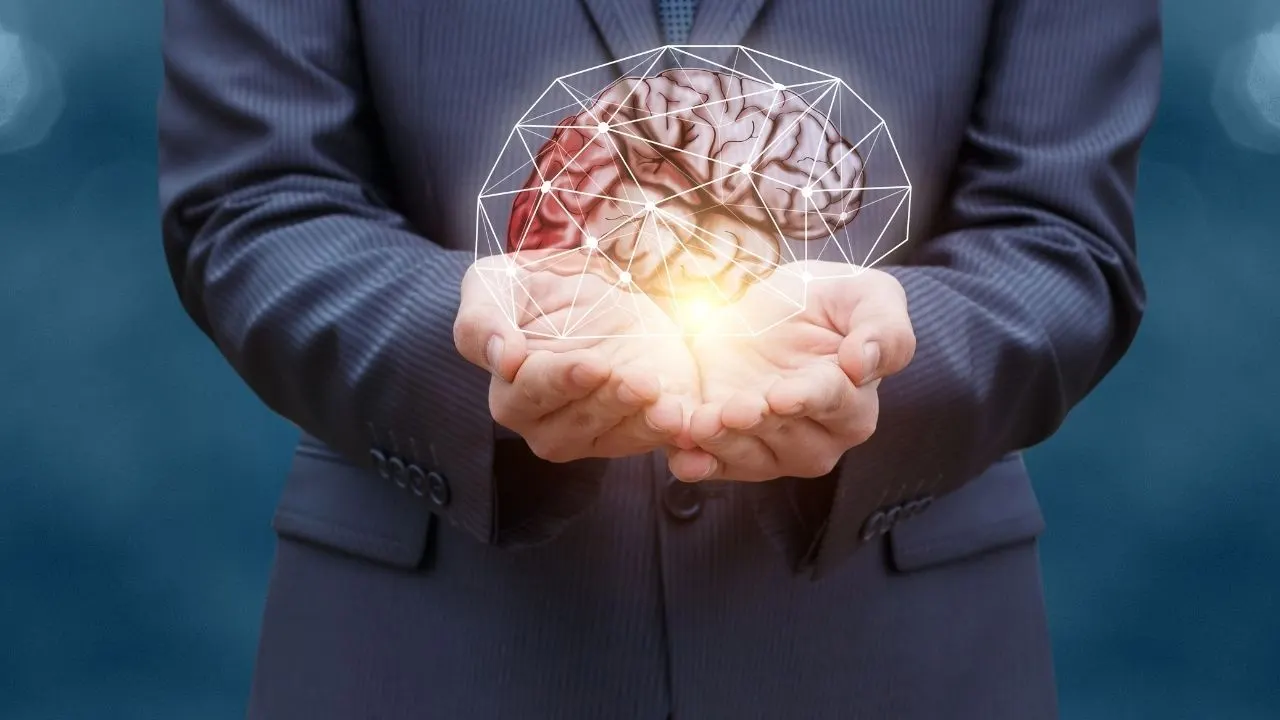 Executive holding a brain in his hand in its full complexity and observing it through his awareness
